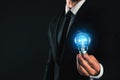 Idea concept. Businessman with glowing light bulb on background, closeup