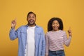 Idea Concept. Cheerful Black Couple Pointing Fingers Up And Looking At Camera Royalty Free Stock Photo