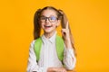 Excited School Girl Pointing Finger Up Over Yellow Background