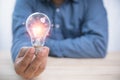 Idea concept inspiration and innovation. Businessman holding a bright light bulb with copy space. Creativity innovation ideas for Royalty Free Stock Photo