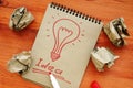 Idea concept. Light bulb as symbol of creativity. Success and sheets of paper after unsuccessful attempts.