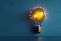 Idea concept Yellow light bulb shining on a blue background Royalty Free Stock Photo