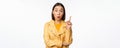 Idea. Enthusiastic asian girl has suggestion, raising finger up, eureka gesture, got excellent plan or solution Royalty Free Stock Photo