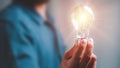 Idea innovation and inspiration concept.Hand of man holding illuminated light bulb, Royalty Free Stock Photo