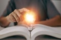 Idea of learning education knowledge online class or e-learning at home. Glowing light bulb and book Royalty Free Stock Photo