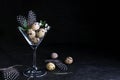 Idea of modern easter interior decoration. Quail eggs in cocktail glass on dark rusty background. Copyspace Royalty Free Stock Photo