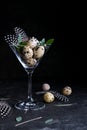 Idea of modern easter interior decoration. Quail eggs in cocktail glass on dark rusty background. Copyspace Royalty Free Stock Photo