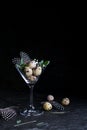 Idea of modern easter interior decoration. Quail eggs in cocktail glass on dark rusty background. Copyspace Royalty Free Stock Photo
