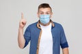 Idea. Portrait of excited young man in casual style with surgical medical mask standing, finger up and looking at camera with