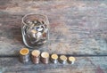 The idea of saving money for future finances, accumulating money in a glass jar, and a pile of coins is vertical Royalty Free Stock Photo