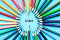 Idea sharing concept, multicolored pencils on blue background