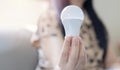 Idea for success concept. Energy saving lamp in woman\'s hand, close-up of a woman holding a glowing light bulb Royalty Free Stock Photo