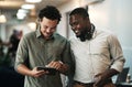 Ideas are better shared. two young businessmen standing together in the office and using a digital tablet. Royalty Free Stock Photo