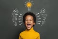 Ideas and brainstorm concept. Happy child school student with lightbulb and chalk question marks Royalty Free Stock Photo