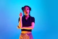 Ideas. Portrait of young, emotive, korean girl posing with raised finger against blue studio background in neon light