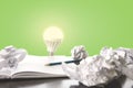 Ideas / trial and error concept image with scrunched paper, pencil and light bulb lighting up Royalty Free Stock Photo