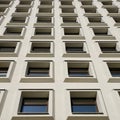 Identical convex windows of a concrete building. Uniform windows of a with niches for glass, close-up Royalty Free Stock Photo