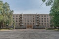 Identical old shabby brick Soviet five-story house in cloudless sunny day