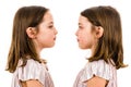 Identical twin girls are looking at each other and smiling