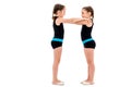 Identical twin girls practice and doing rhythmic gymnastics, white background Royalty Free Stock Photo