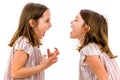 Identical twin girls sisters are arguing yelling at each other