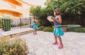 Identical twin sisters are playing on vacation with hula hoop Royalty Free Stock Photo