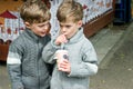 Identical twins are drinking tea in the park