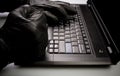 Identity theft, hacker working on laptop