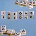 idioms - word from plastic blocks with letters and reflections, mode of expression concept, random letters around