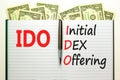 IDO initial DEX offering symbol. Concept words IDO initial DEX offering on beautiful white note. Dollar bills. Beautiful dollar