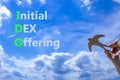 IDO initial DEX offering symbol. Concept words IDO initial DEX offering on beautiful blue sky clouds background. Wooden bird.