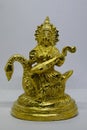 Idol of Goddess Devi Saraswati made of brass, isolated on a white background. Close up