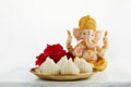 Idol of lord Ganesha with Modak Sweet Dish and flower. Ganesh chaturthi