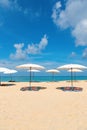 Idollic beach relaxing concept with white parasols on sand Royalty Free Stock Photo