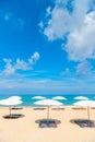 Idollic beach relaxing concept with white parasols on sand Royalty Free Stock Photo