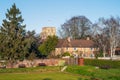 An idylic scene including woodland, the edge of a bowling green, a county house and St Clements church in Sandwich, Kent, UK