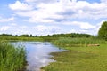 Idyll summer countryside landscape by the river. Boat by the bank, rushes and grass. Wild nature by Biebrza river with beautiful Royalty Free Stock Photo