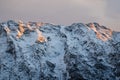 Idyllic alpine snowy mountain chain peak view in orange sunset sky, julian alps, Slovenia Royalty Free Stock Photo