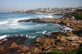 Idyllic and amazing seaside landscape of beaches, jagged coast with rocks, rushing white ocean waves and buildings on hills