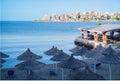 Idyllic beach with restaurant and sun umbrellas in Saranada Albania. Umbrellas on a pebble beach