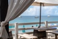 Idyllic beach restaurant with wooden tables and benches and white umbrellas