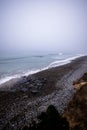 Idyllic beach scene with tranquil ocean fog rolling in and wispy clouds above Royalty Free Stock Photo