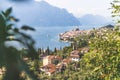 Idyllic coastline scenery in Italy: Blue water and a cute village at lago di garda, Malcesine Royalty Free Stock Photo