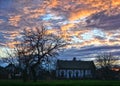 An idyllic countryside sunset with a tree and the house