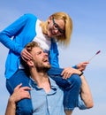 Idyllic date concept. Man carries girlfriend on shoulders, sky background. Woman enjoy perfect romantic date. Couple in