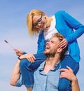 Idyllic date concept. Man carries girlfriend on shoulders, sky background. Woman enjoy perfect romantic date. Couple in