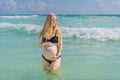 In the idyllic embrace of the Caribbean Sea, a pregnant woman finds bliss, savoring the warmth and serenity of the