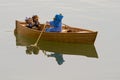 Three dolls in a toy boat on lake Royalty Free Stock Photo