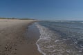 Idyllic golden sand beach in northern Denmark with sand dunes and gentle waves lapping at the shore Royalty Free Stock Photo