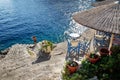 Idyllic Greek Island Hydra. 2 chairs and a small table. Steep descent to the water